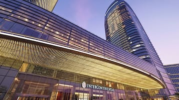 Un hotel moderno con una llamativa fachada de vidrio curvo y una estructura sobresaliente distintiva.