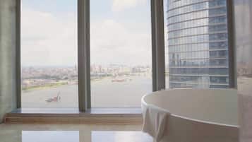 A room with a large window, a white table, and a view of a cityscape and river.