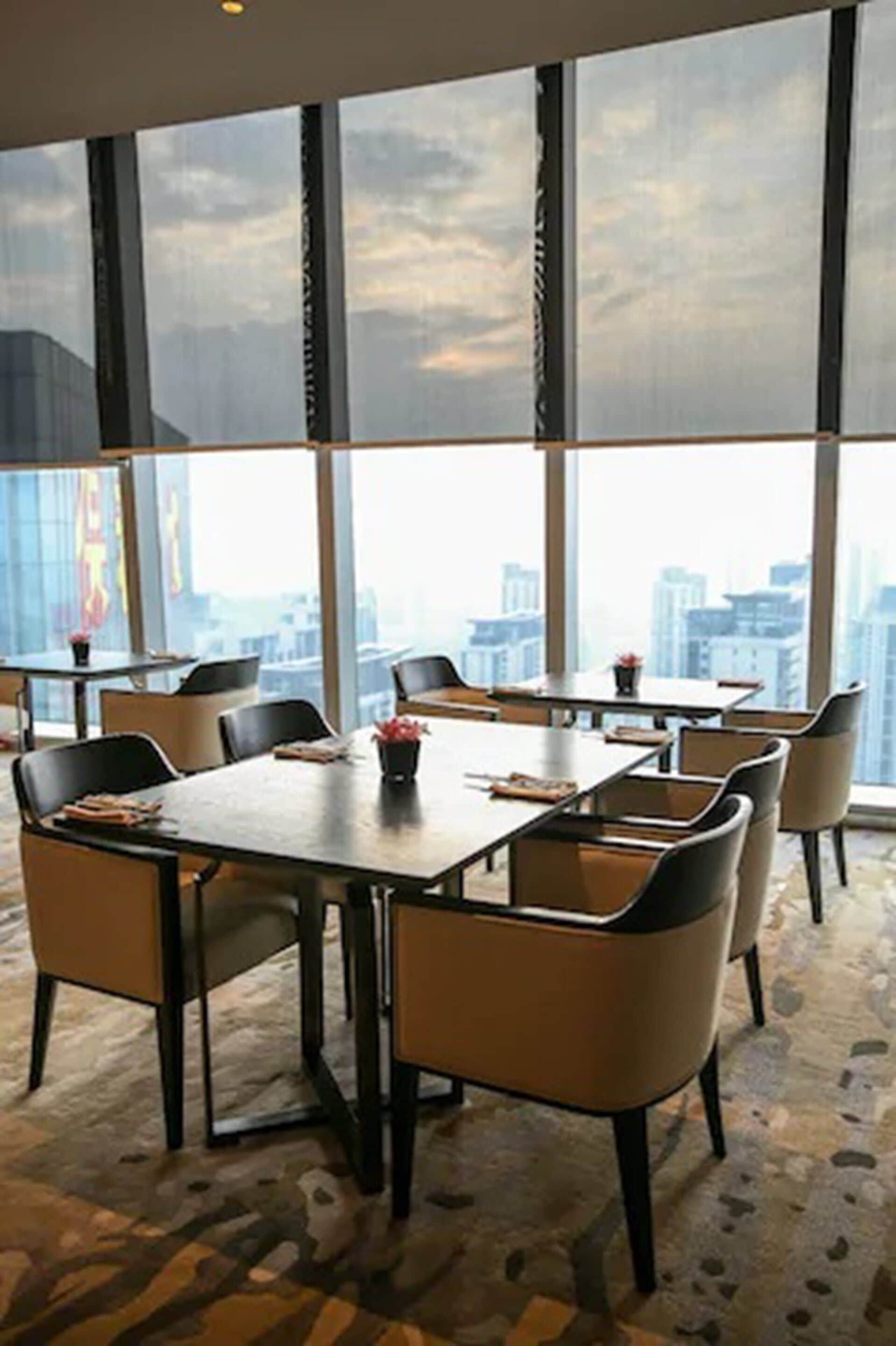 A conference room with large windows, a city view, and a carpeted floor.