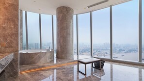 A high-rise hotel room with a large bathtub, a marble floor, and a view of a cityscape through floor-to-ceiling windows. - InterContinental Guangzhou Exhibition Center by IHG (Guangzhou)