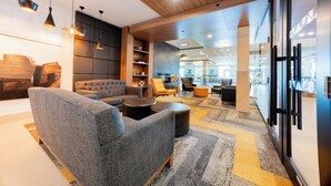 Ein stilvoller Lounge-Bereich mit Sofas, einem Couchtisch und Pendelleuchten.