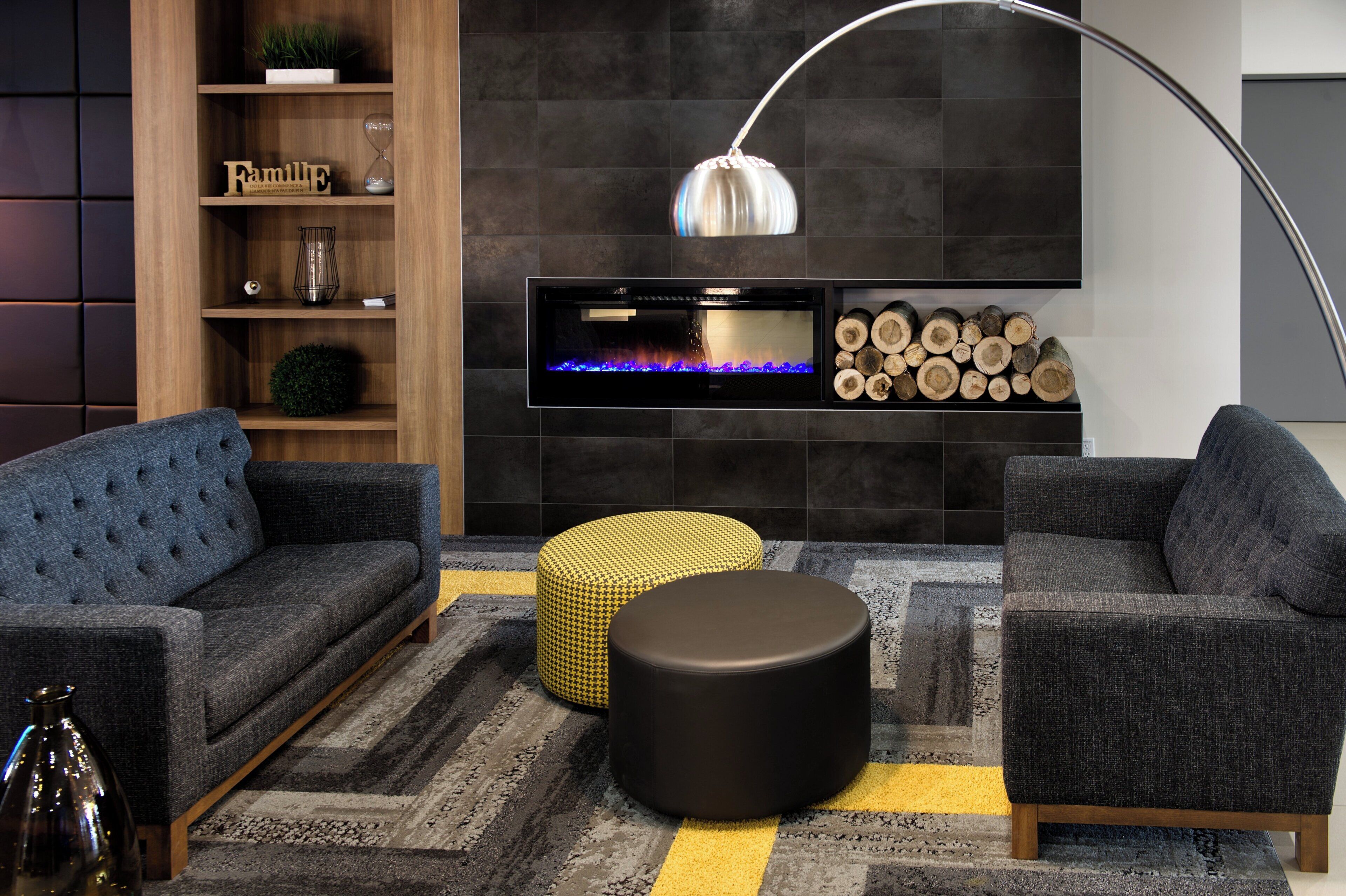 Una sala de estar moderna con chimenea, dos sofás, una mesa de centro y una lámpara de pie.