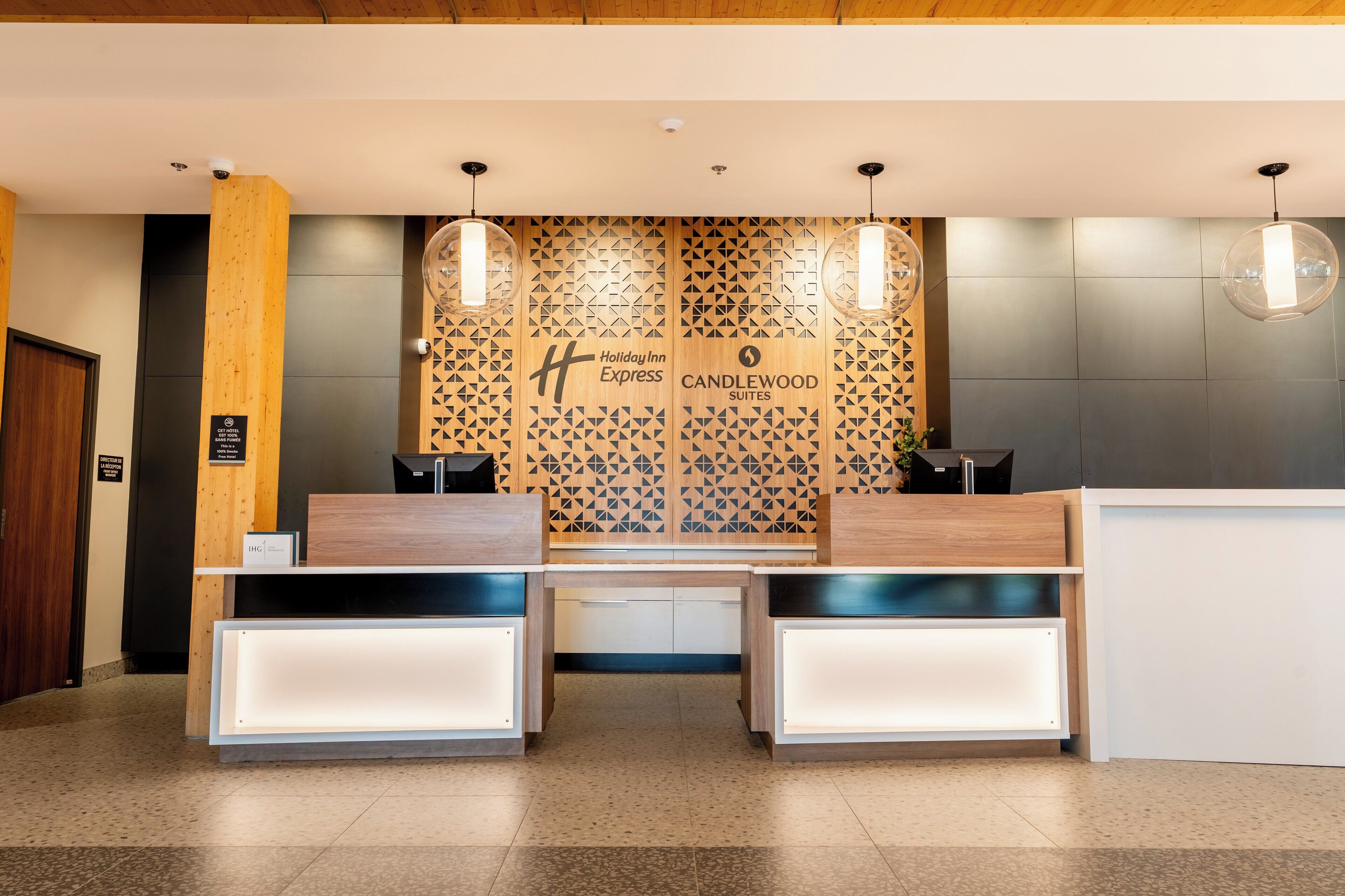 A reception desk with a modern design, featuring a geometric patterned wall behind it.
