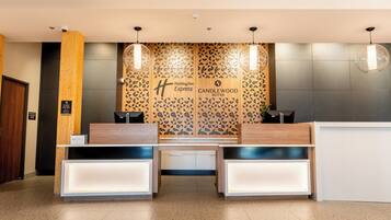 A reception desk with a modern design, featuring a geometric patterned wall behind it.