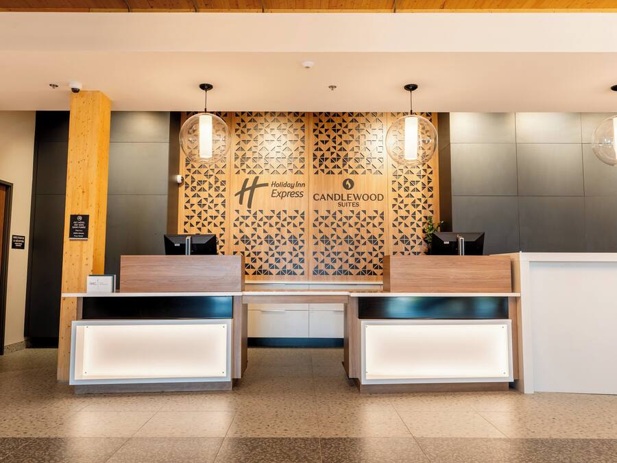 A reception desk with a modern design, featuring a geometric patterned wall behind it.