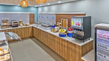 A modern breakfast bar with a variety of food options, including a yogurt machine and a display of eggs and milk.