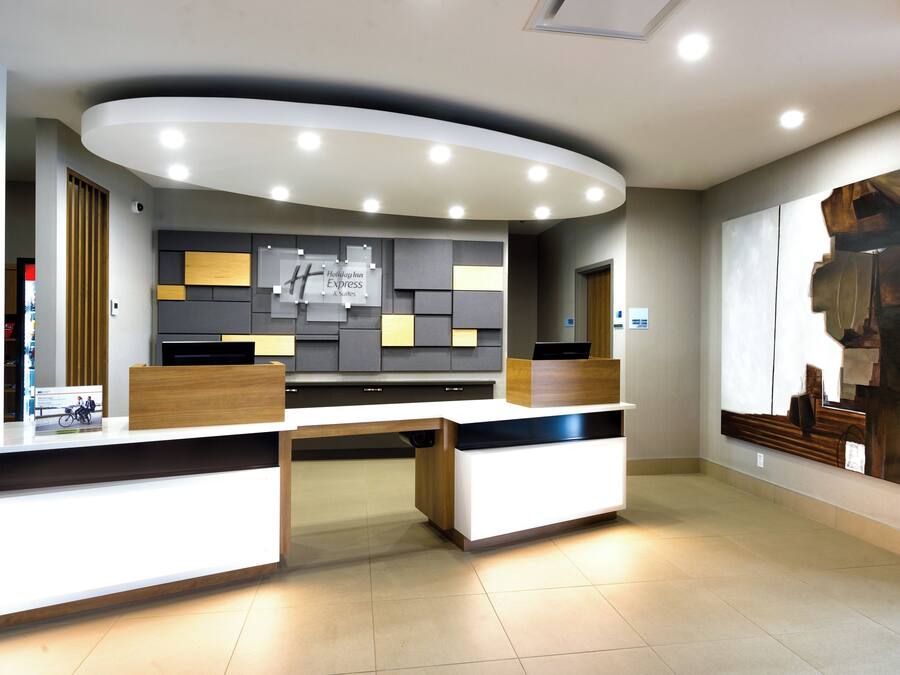 En receptionsdisk med modern design, en stor abstrakt målning på väggen och en skylt som visar hotellets namn.