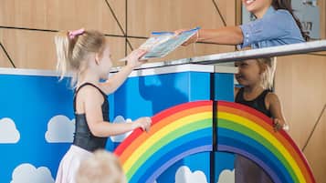 Children can play and explore in this vibrant play area featuring a large rainbow structure.