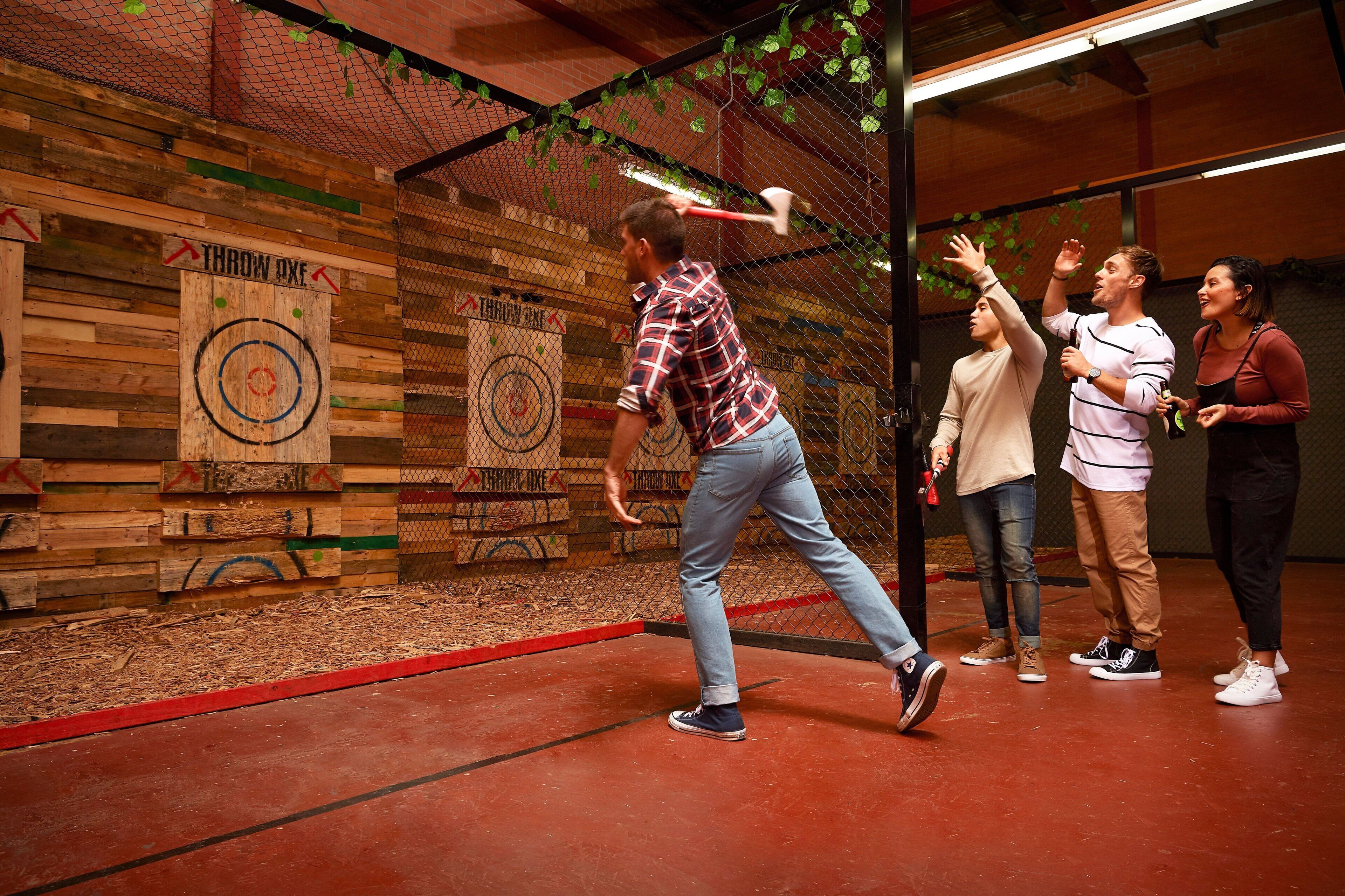 A man playing a game, possibly bowling, indoors with a target on the wall.