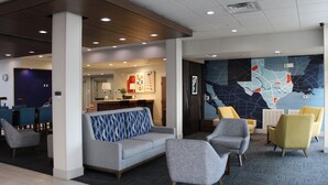 A lobby with a sofa, armchairs, a reception desk, and a map on the wall. - Holiday Inn Express and Suites San Marcos South by IHG (San Marcos)