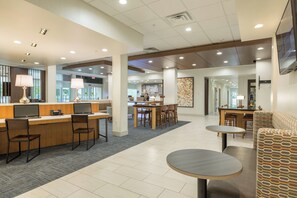 A hotel lobby with a reception desk, seating area, and a dining space. - Holiday Inn Express and Suites San Marcos South by IHG (San Marcos)