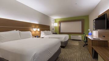 A hotel room with two beds, a desk, a TV, and a large window.