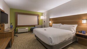 A hotel room with a bed, bedside table, lamp, and a TV on a desk. - Holiday Inn Express and Suites San Marcos South by IHG (San Marcos)