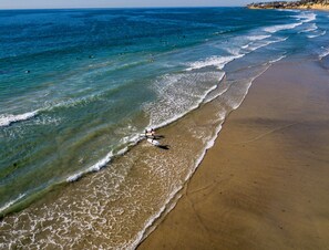 In Strandnähe, weißer Sandstrand, Sonnenschirme, Strandtücher