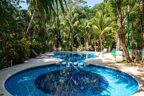 A swimming pool surrounded by palm trees and lounge chairs. - Casa Bella Vista by Playa Paradise (Playa del Carmen)