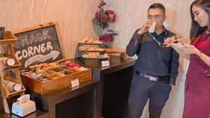 A snack station with a sign reading "SNACK CORNER," featuring various pastries and snacks. - News Front One Hotel Surabaya (Sidoarjo)