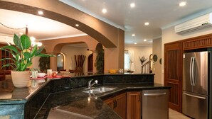 Una cocina moderna con encimera de granito, electrodomésticos de acero inoxidable, armarios de madera y lavavajillas integrado.