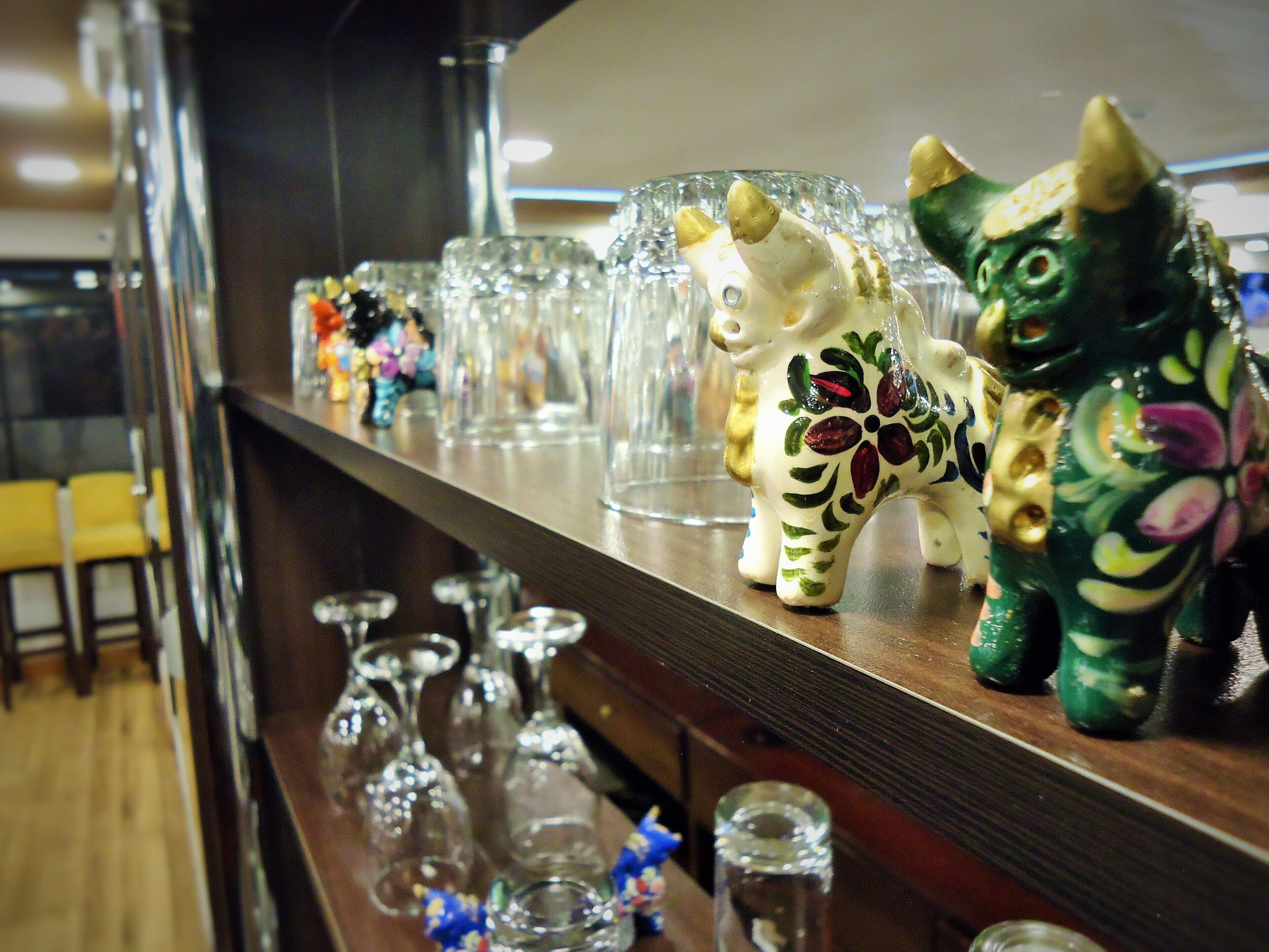 A bar area with decorative ceramic animal figures and a variety of glassware.