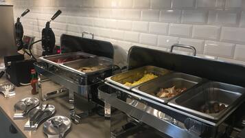 Una mesa de buffet con diferentes alimentos y utensilios.