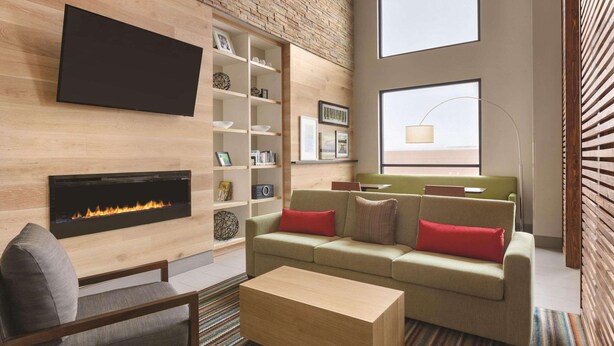 A modern living room with a fireplace, a sofa set, a coffee table, and a bookshelf. - Country Inn & Suites by Radisson, Ocean City, MD (Ocean City)