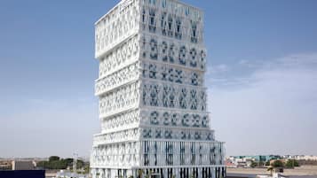 Un edificio moderno de varios pisos con una fachada distintiva de listones verticales.