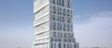 Um edifício moderno de vários andares com fachada singular caracterizada por ripas verticais.