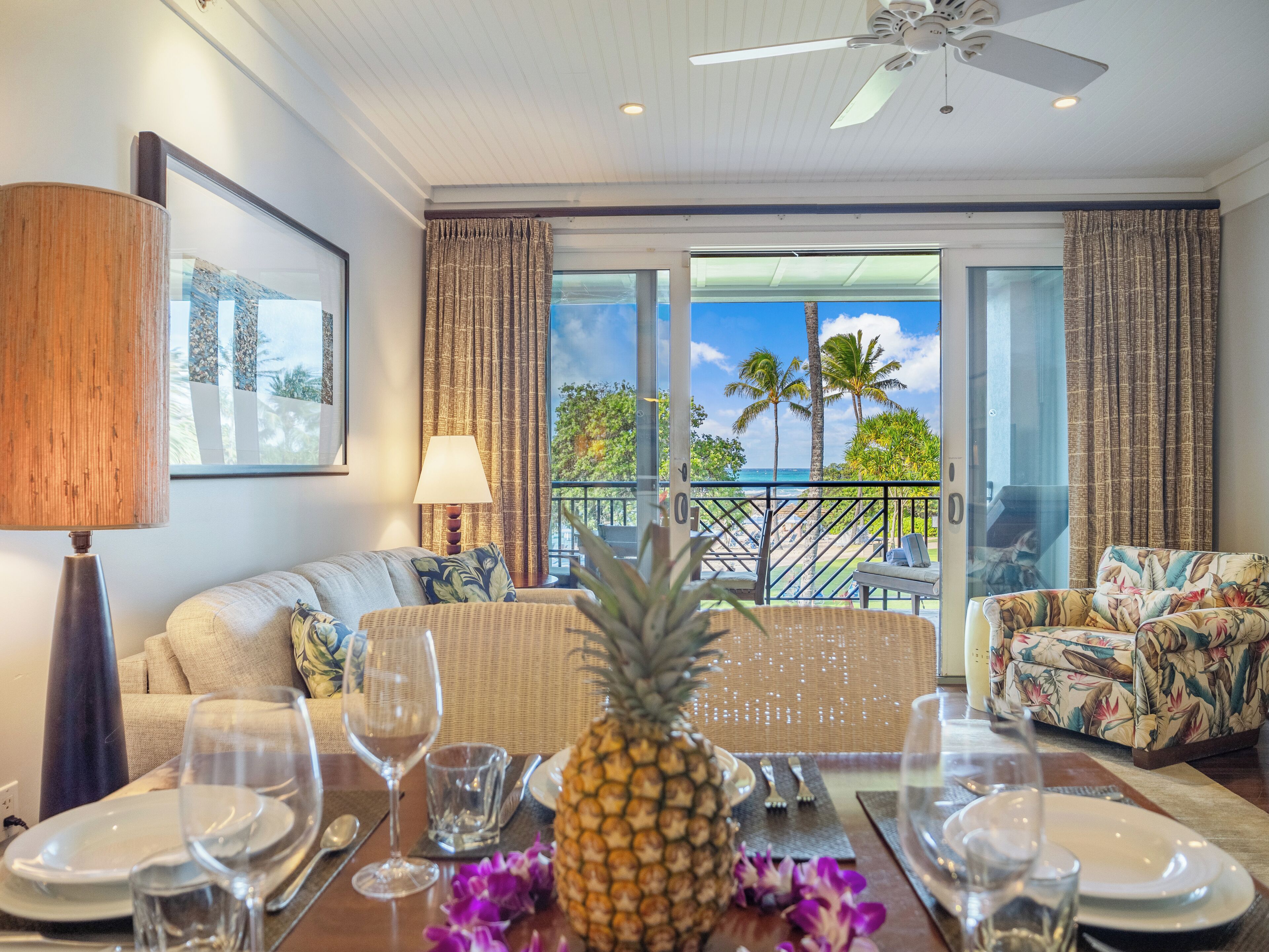 Ein Hotelzimmer mit Balkon, ein Esstisch gedeckt mit Tellern, Gläsern und einer Ananas als Mittelstück.