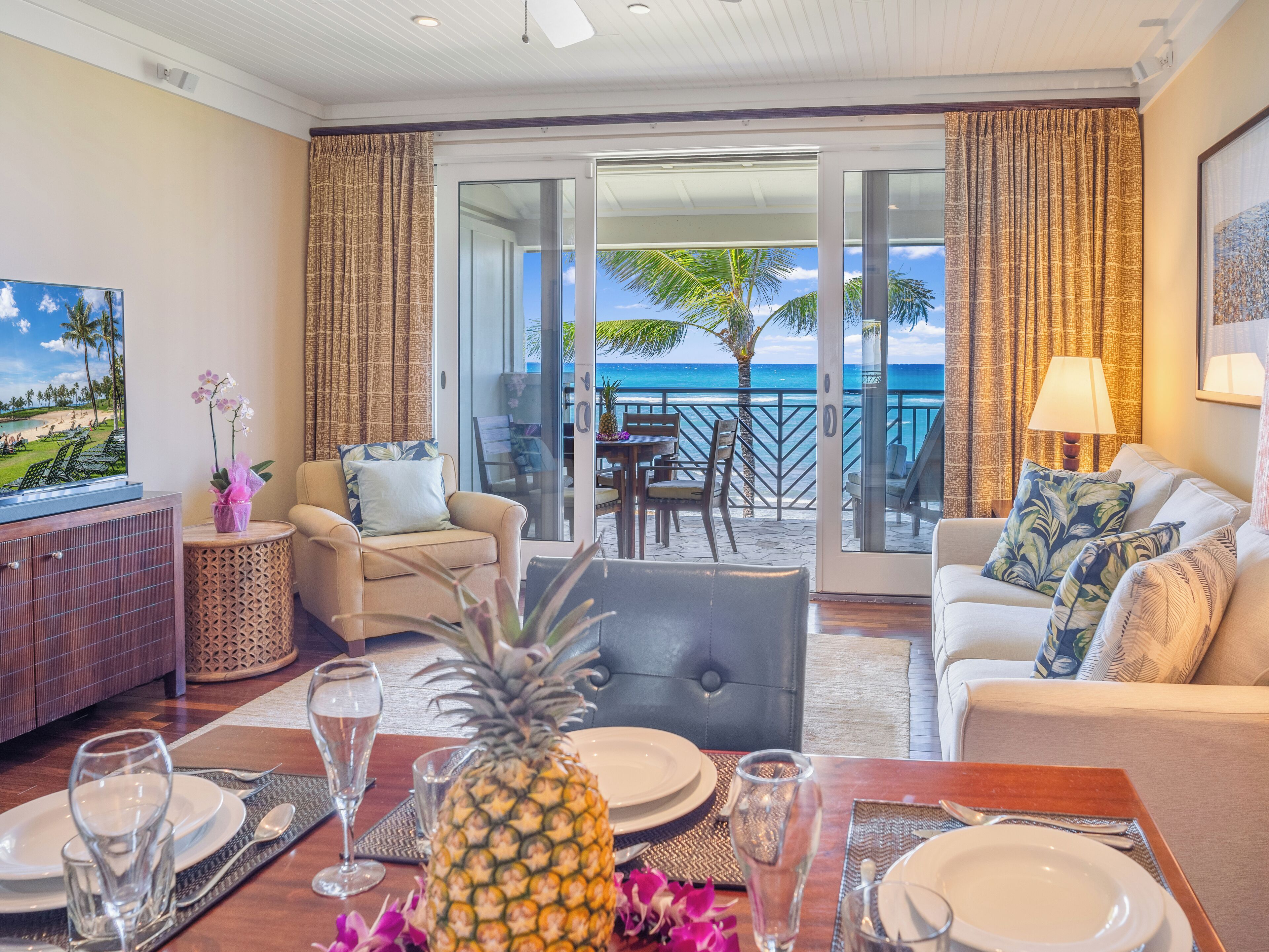 Une chambre d’hôtel avec un balcon, un coin repas et une télévision.