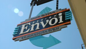 Une enseigne sur laquelle on peut lire les mots « Envoi » et « Innovation », le tout sur fond de ciel bleu clair.