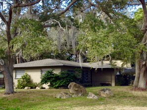 Stroll through the serene surroundings of this charming single-story home, complete with a cozy front porch and lush greenery.