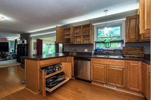 Una cocina moderna con armarios de madera, electrodomésticos de acero inoxidable y un ventanal con vistas al exterior.