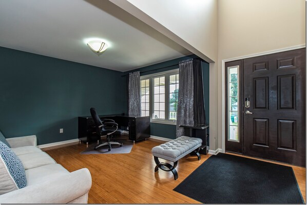 Una habitación con un escritorio, una silla de oficina y un banco.