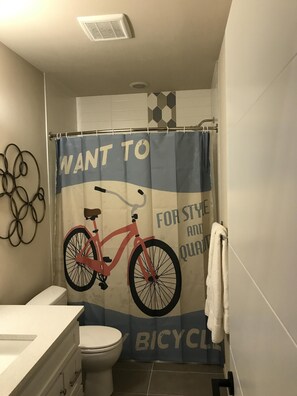 Een bad/douchecombinatie, een haardroger, handdoeken, shampoo