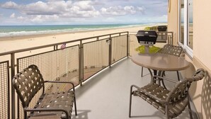 A balcony with a view of the beach, a round table, and two chairs. - Luxury Vacation Condos at Seaside Oceanfront Resort (Seaside)