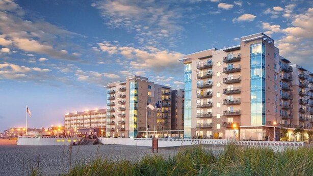 A modern hotel with multiple floors, balconies, and a waterfront location. - Luxury Vacation Condos at Seaside Oceanfront Resort (Seaside)