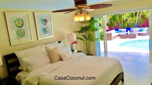 A bedroom with a bed, a ceiling fan, and a view of a swimming pool.