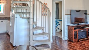 Un escalier en colimaçon avec des rampes blanches menant à un deuxième étage.