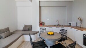 A modern kitchen with a dining area, a built-in bench, and a ceiling fan. - Pyrgos Exclusive 2, Sea View & Private Pool (Plakias)