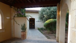 Un chemin de pierre menant à l’entrée d’un spa, avec un sol carrelé et une plante en pot.