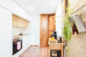 A compact kitchen with white cabinets, a patterned floor, and a wooden door. - Penthouse Cathedral Quarter Mester Apartments .central A/C and high speed wifi (València)