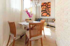 A dining area with a round table, wooden chairs, and a vase with flowers. - Penthouse Cathedral Quarter Mester Apartments .central A/C and high speed wifi (València)