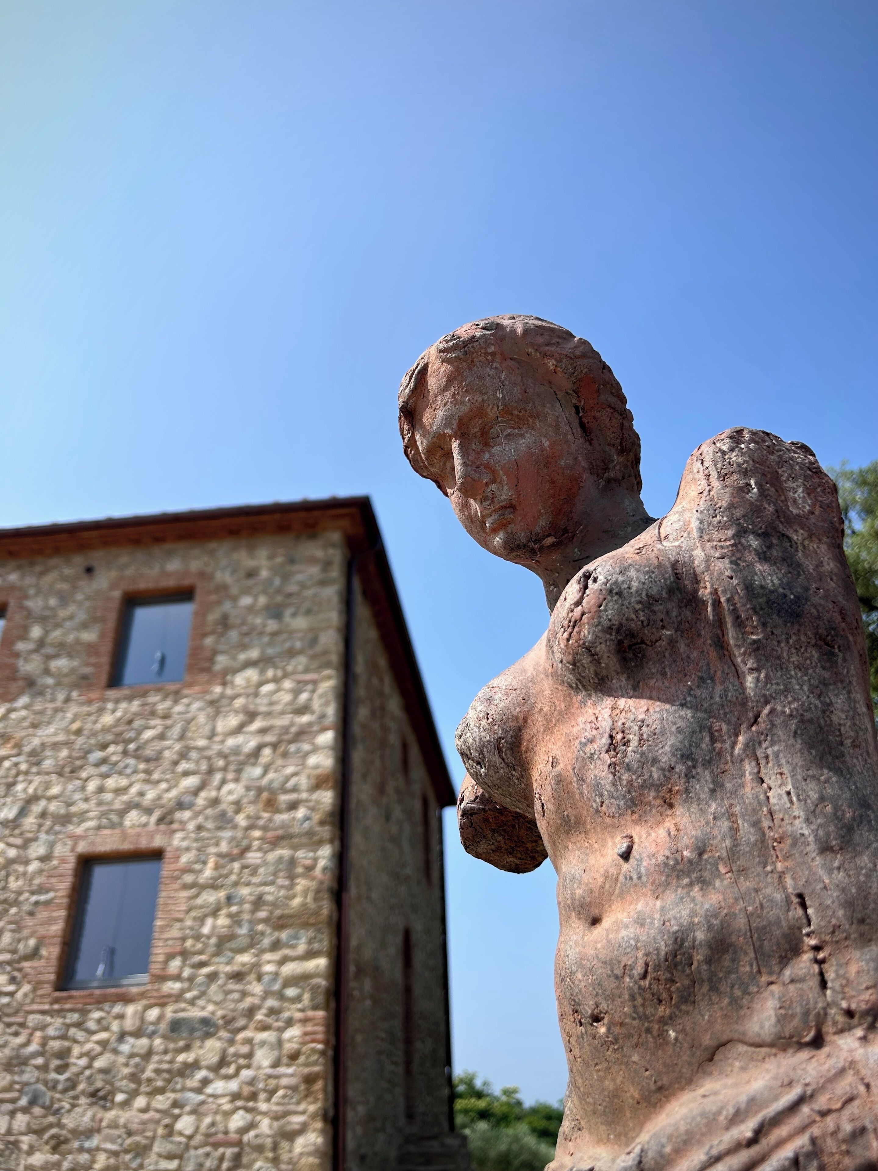 Un edificio de piedra con una estatua en primer plano.