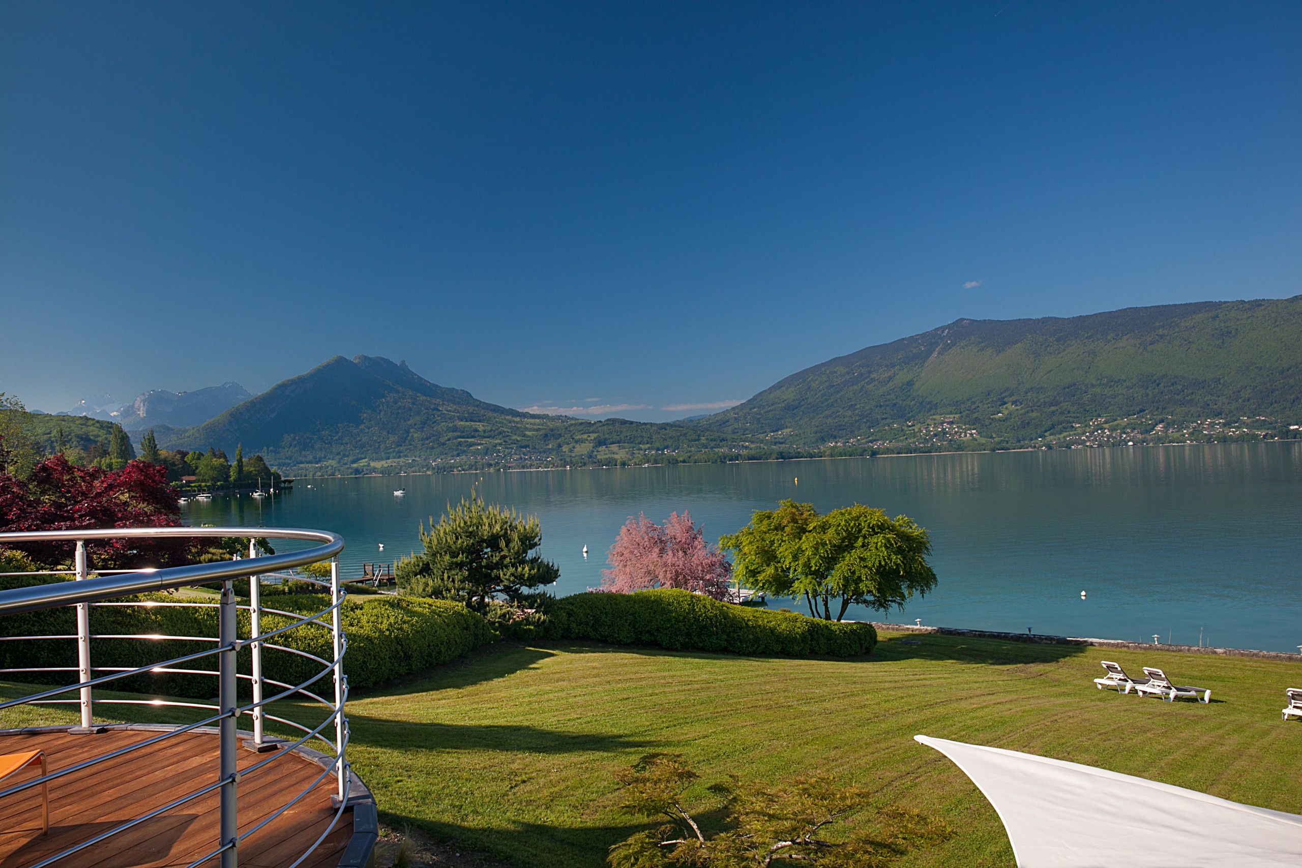 Une vue sur le lac, avec une terrasse en bois et des chaises longues.