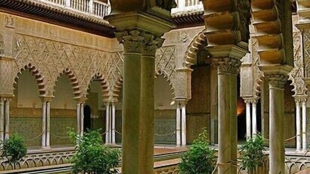 Un cortile interno con archi, colonne e pavimento piastrellato.