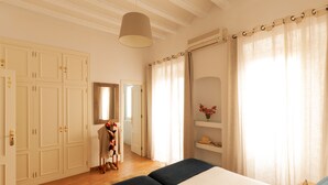 Una camera da letto con un letto, un armadio, uno specchio e un lampadario.
