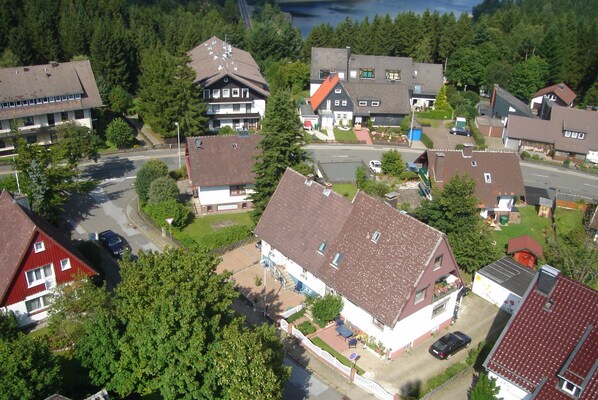 An aerial view of a residential area with houses, a road, and a body of water in the background.