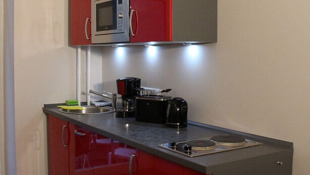 Angolo cottura funzionale con forno a microonde, tostapane e macchina del caffè.
