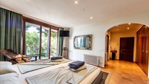 Een hotelkamer met twee bedden, een televisie, een grote spiegel en uitzicht op het omliggende landschap.