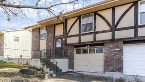 A two-story building with a garage and a small front porch. - Spacious and comfortable 3 bedrooms house in the heart of Overland Park (Overland Park)