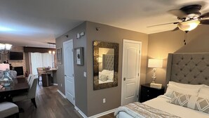 A modern bedroom with a large bed, a ceiling fan, and a nightstand with a lamp. -  Lake Life Luxury, Lake Geneva, Short Walk To Downtown, Pool View Upgraded Suite (Lake Geneva)
